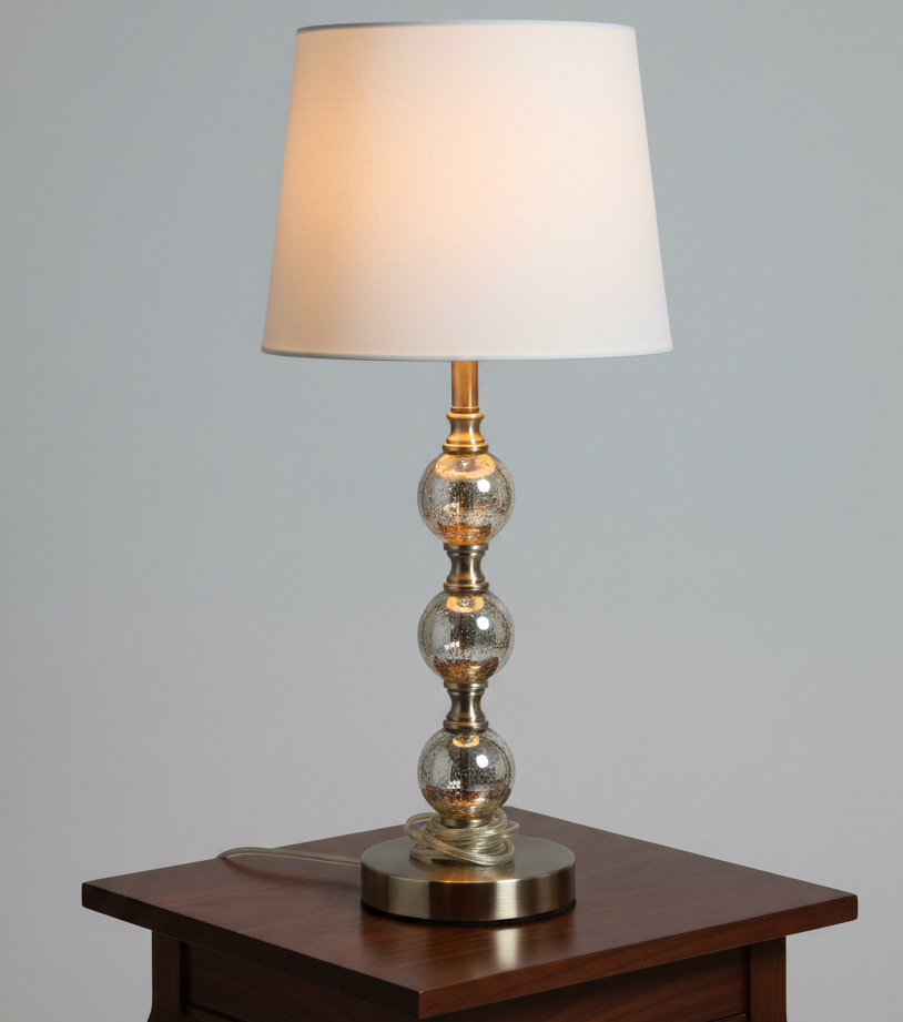 Decorative table lamp with a metallic base and glass shade on a white background