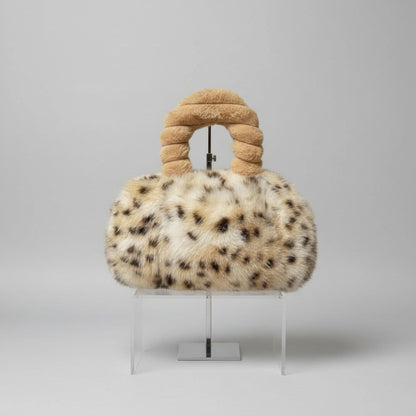 Furry handbag with a knotted handle on a white background