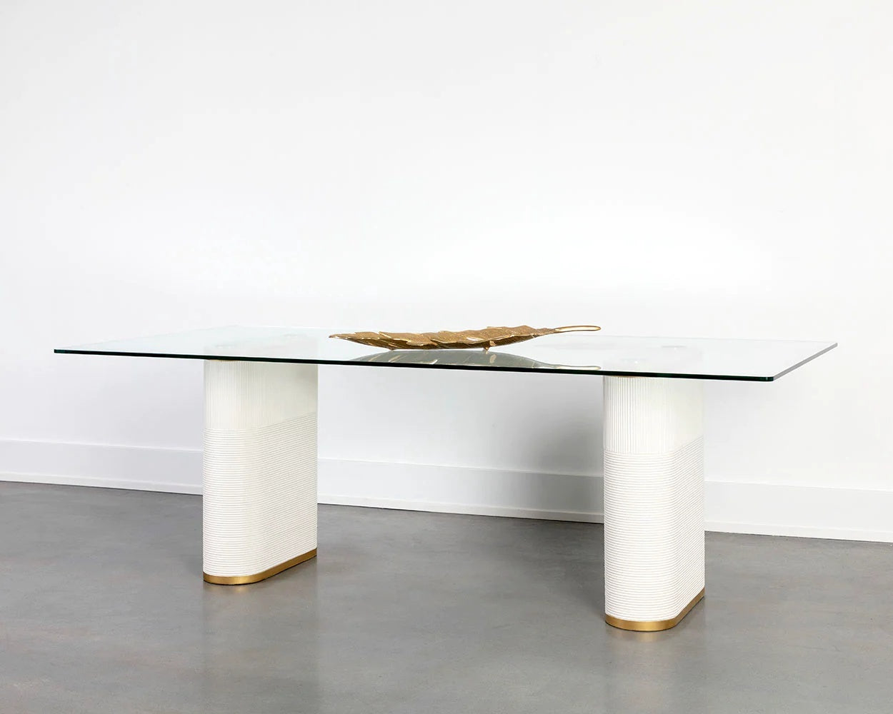 Aemond Dining Table, a rectangular clear glass tabletop that sits on two white concrete legs