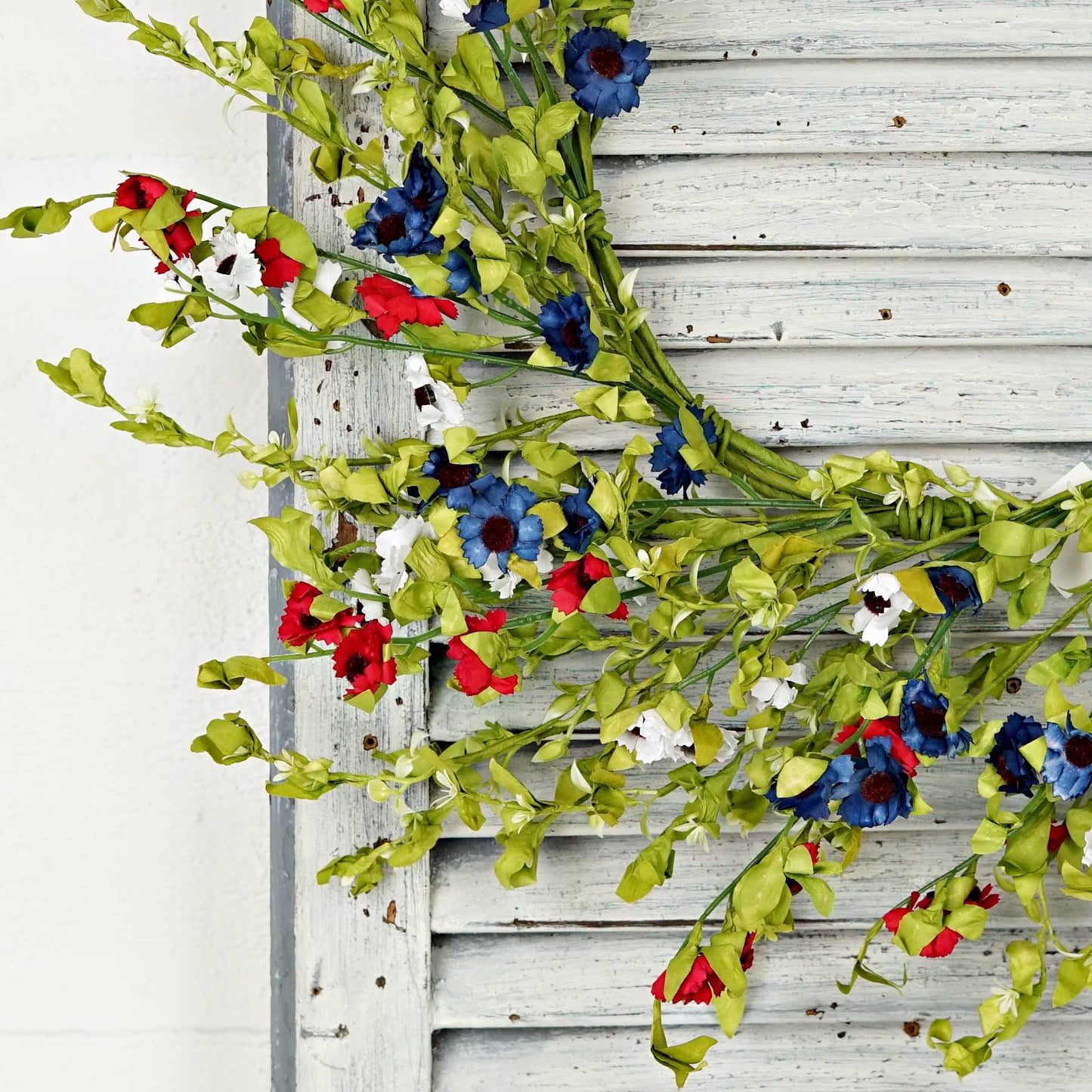 Decorative floral garland with red, blue, and white flowers 