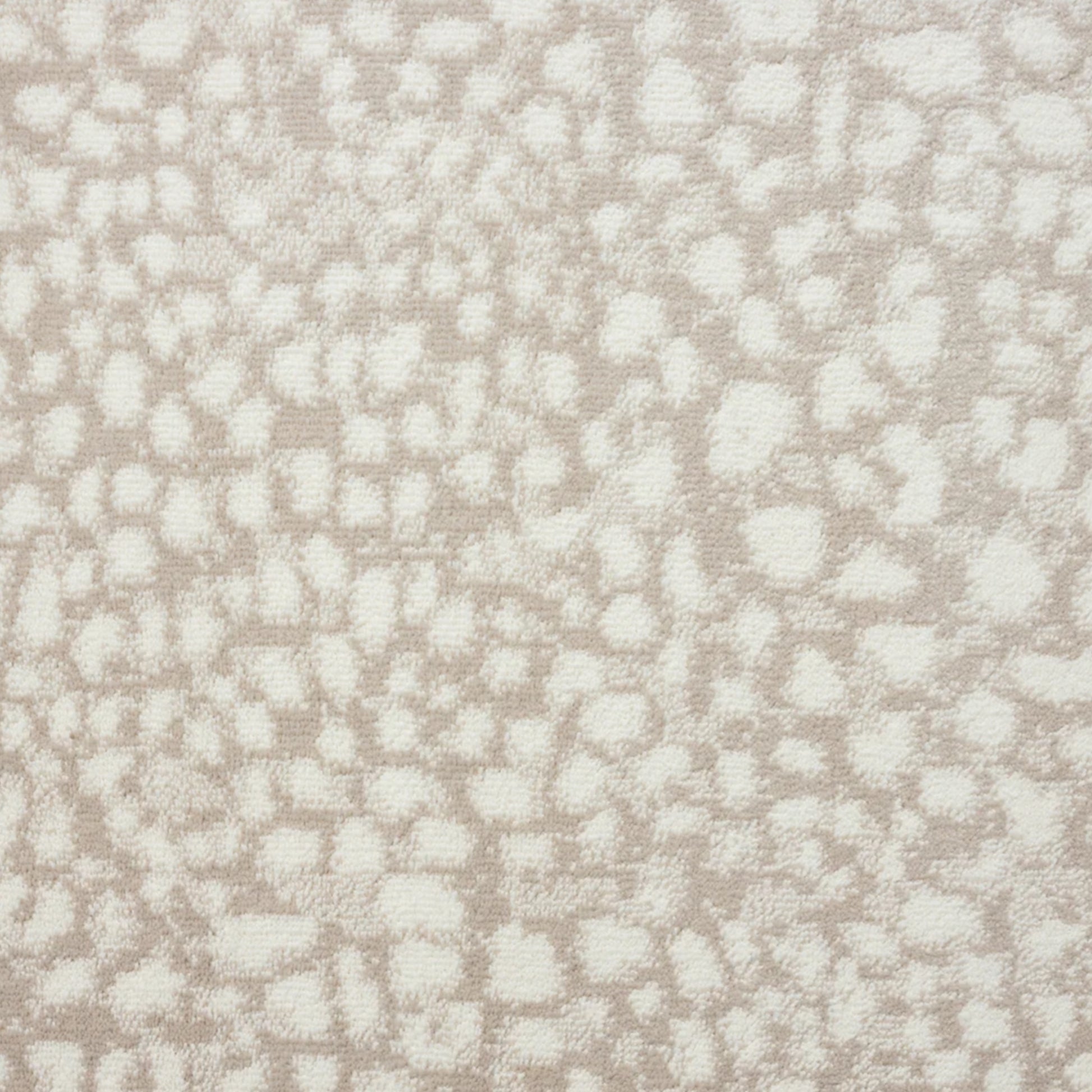 A close-up of a textured fabric or wallpaper pattern featuring an animal print motif in warm beige and off-white.