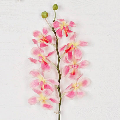 Artificial pink orchid branch on a white background