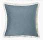 Blue pillow with white fringe on a white background