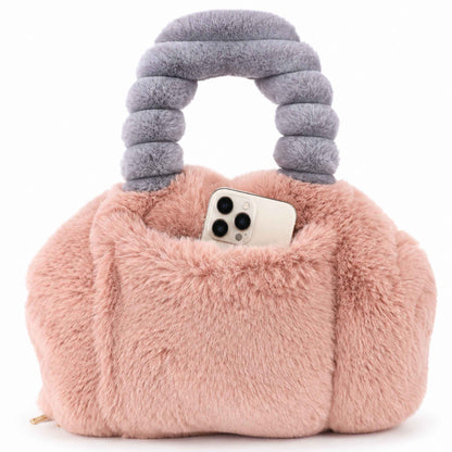 A pink faux fur Pur-Low with a thick, ribbed gray handle, shown with a white smartphone tucked into its front pocket against a white background.