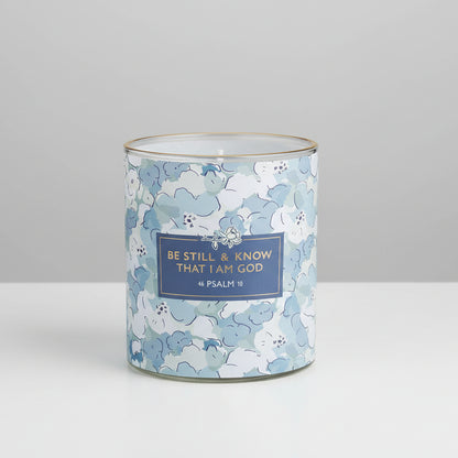 Candle in a floral-patterned container with a motivational quote