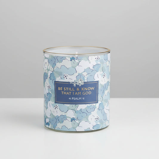 Candle in a floral-patterned container with a motivational quote