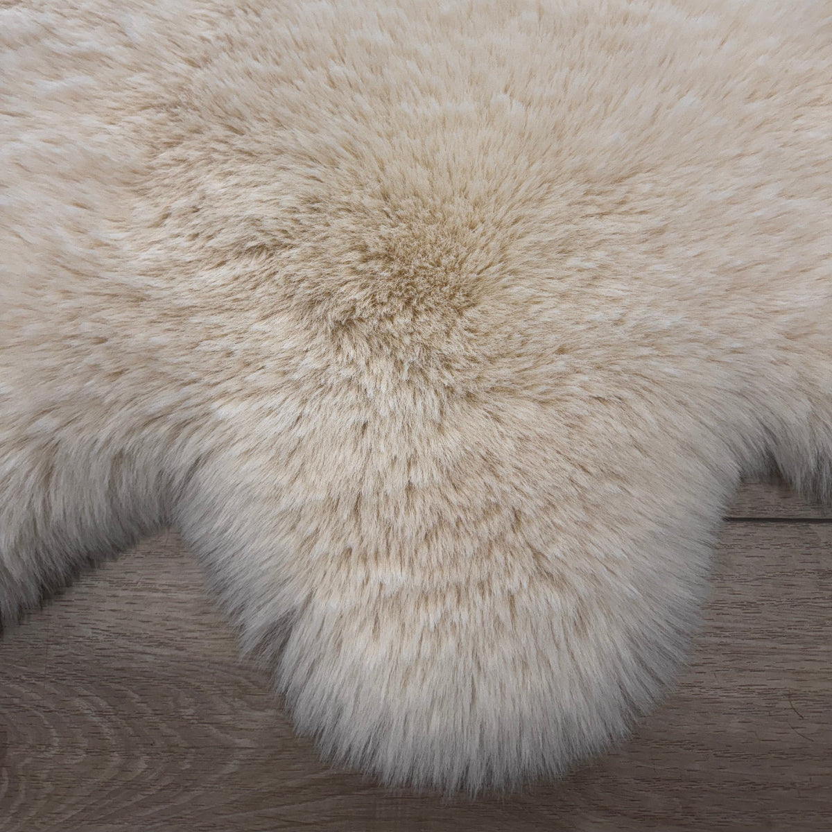 Close-up of a fluffy white rug on a wooden floor