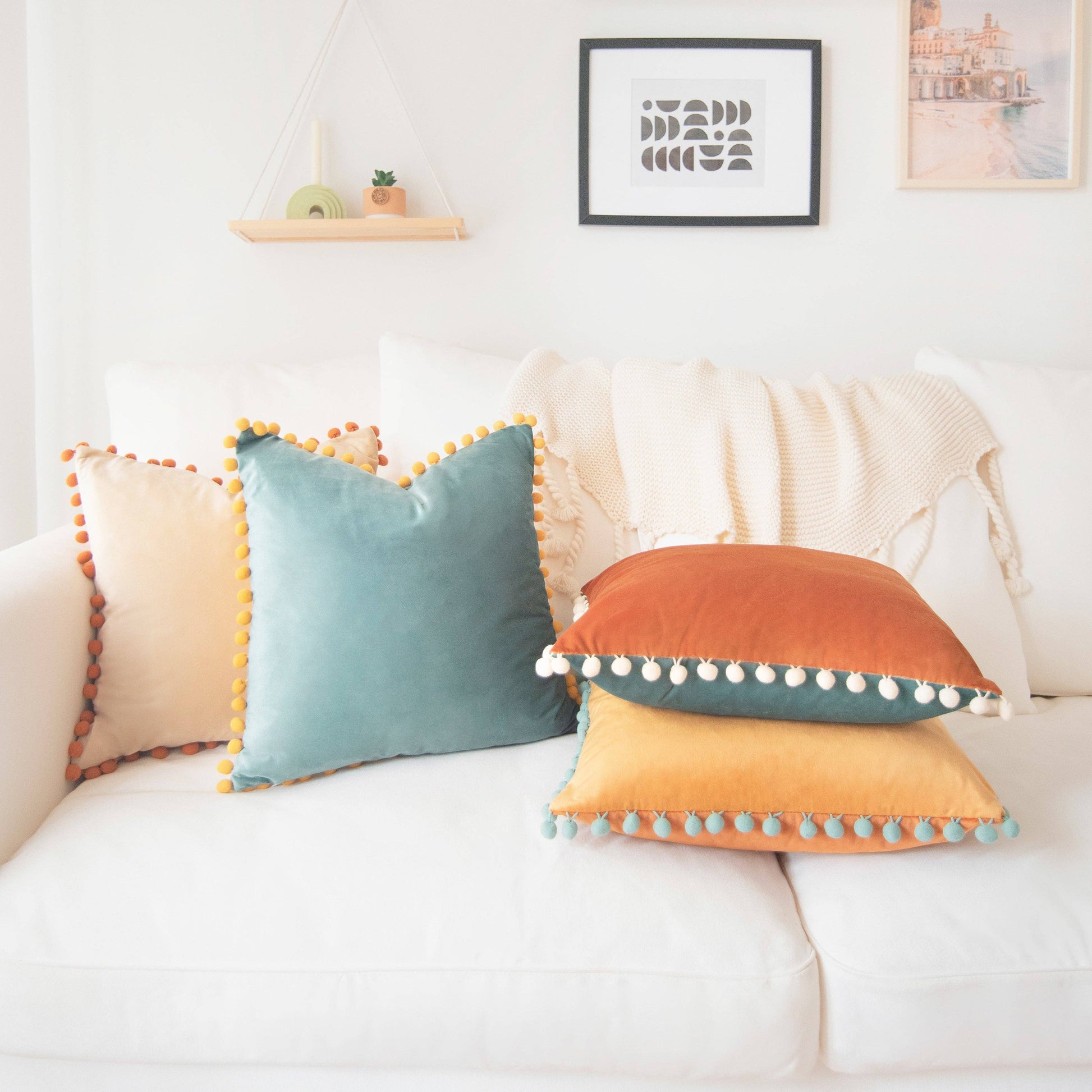 Colorful pillows with pom-pom details on a white couch