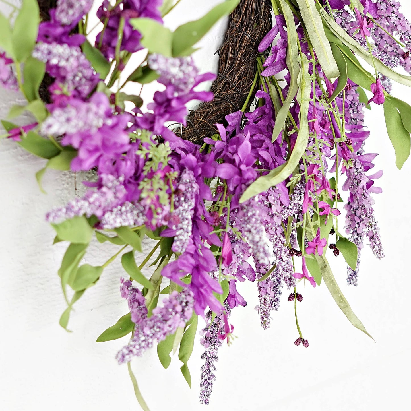 Floral wreath with purple flowers and green leaves on a white background