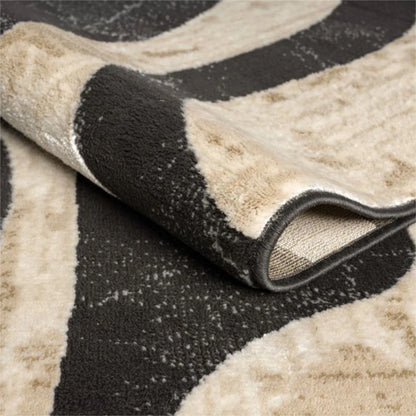 Close-up of a patterned rug with black, beige, and gray colors.