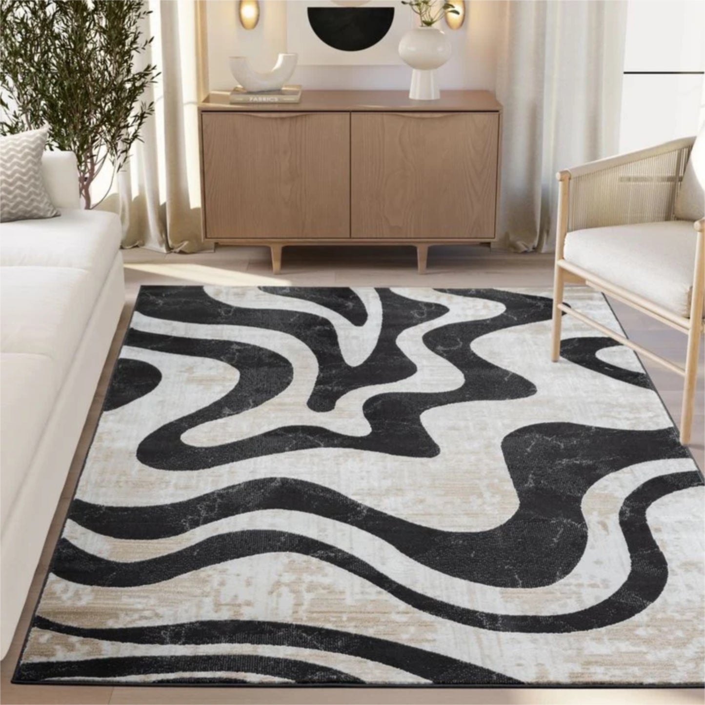 Living room with a black and white patterned rug, beige sofa, wooden cabinet, and decorative items.