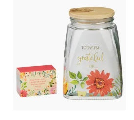 Glass jar with floral design and wooden lid on a white background