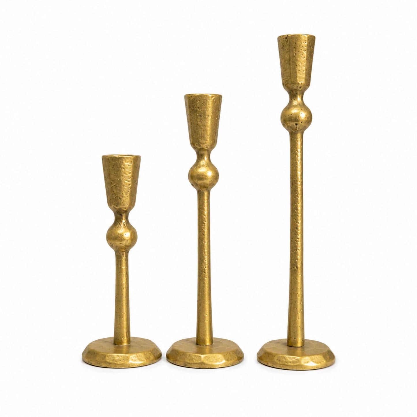 Three gold candle holders of varying heights