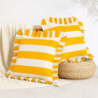 Yellow and white striped pillows with ruffles on a neutral background