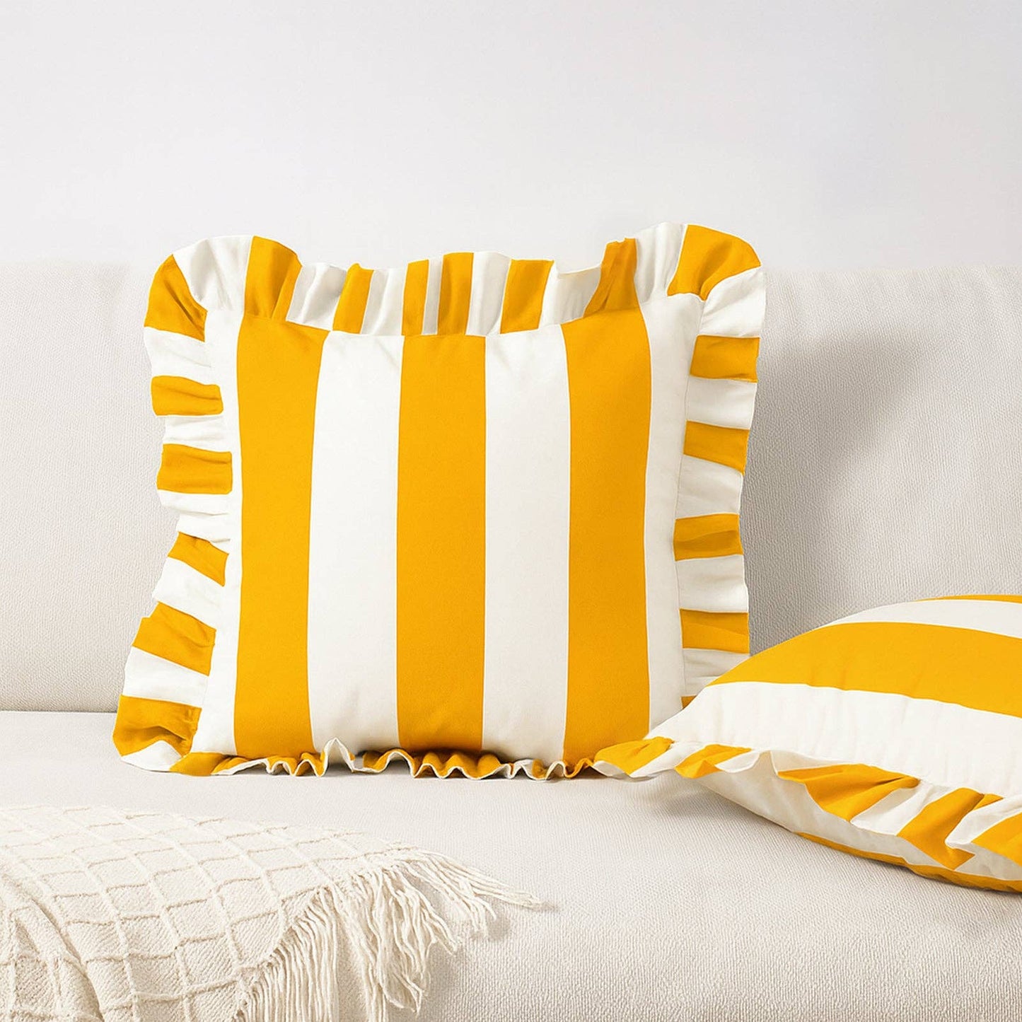 Yellow and white striped pillows on a light-colored couch.