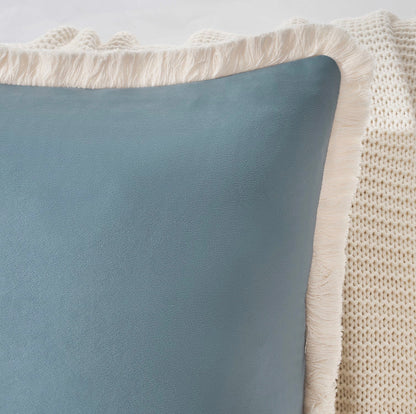 Gray pillow with textured beige border on a light gray background