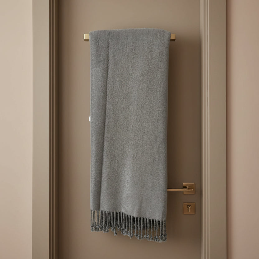Gray throw blanket with tassels on a white background