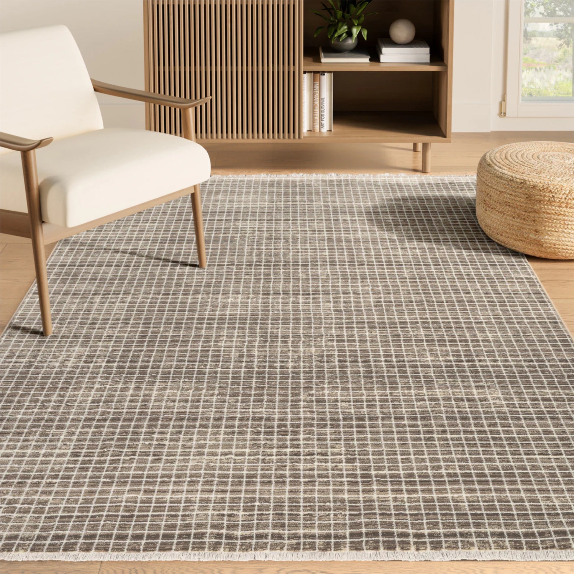 Living room with a grid-patterned rug, white chair, and wooden ottoman.