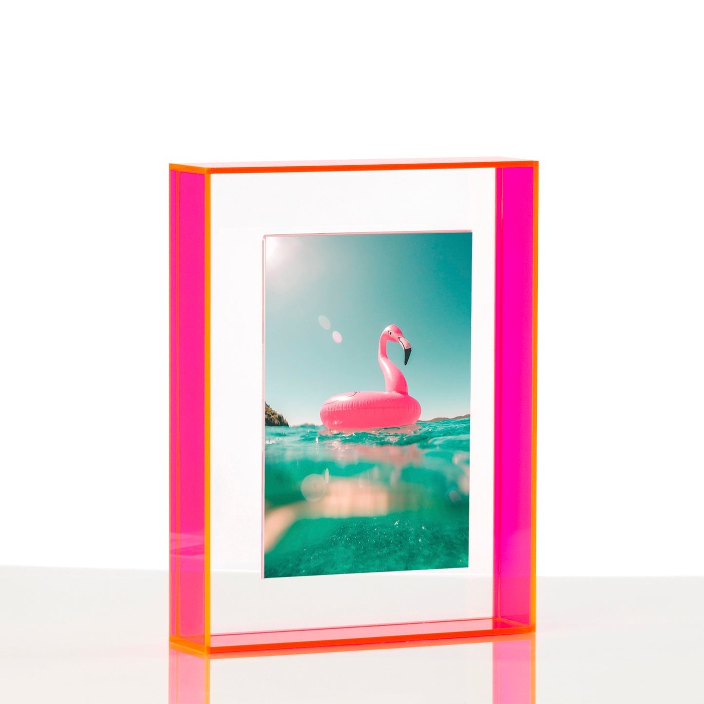 Pink flamingo pool float in a clear blue pool with a colorful frame.