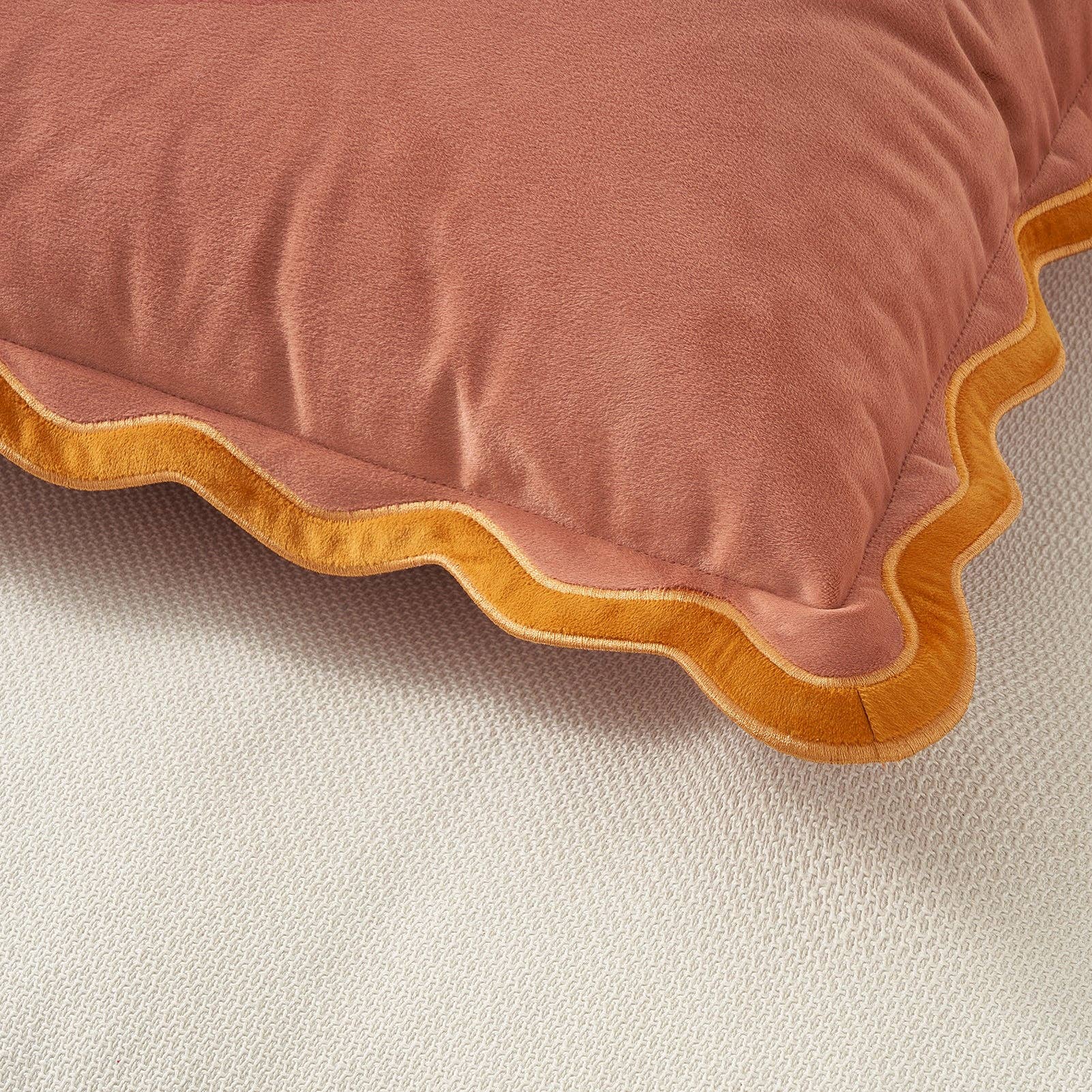 Pink pillow with yellow trim on a beige background