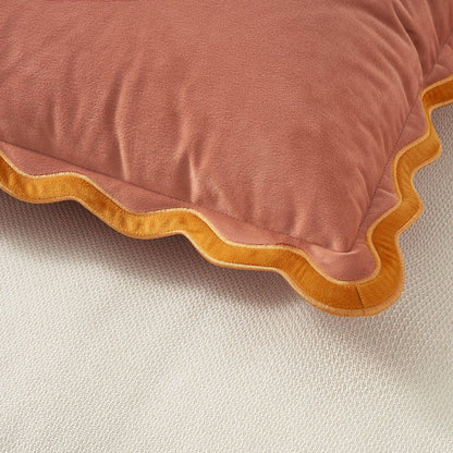 Pink pillow with yellow trim on a beige background