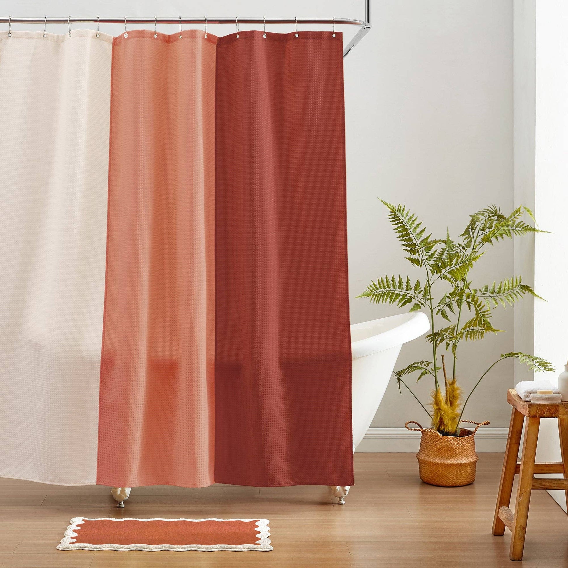 Reddish-brown shower curtain with a plant and stool in a bathroom setting