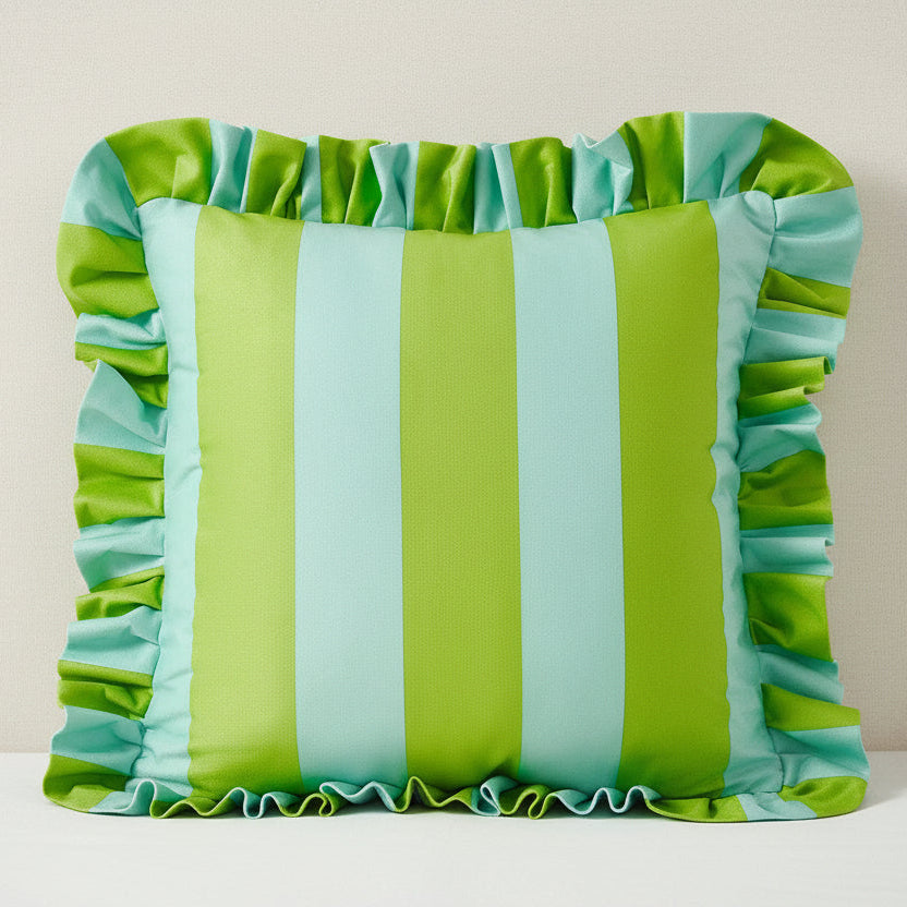 Striped pillow with ruffled edges in green and blue on a plain background