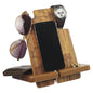 Wooden multi-device stand holding a phone, sunglasses, wallet, and watch on a white background
