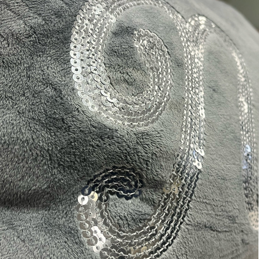 Silver sequin on a textured gray fabric background