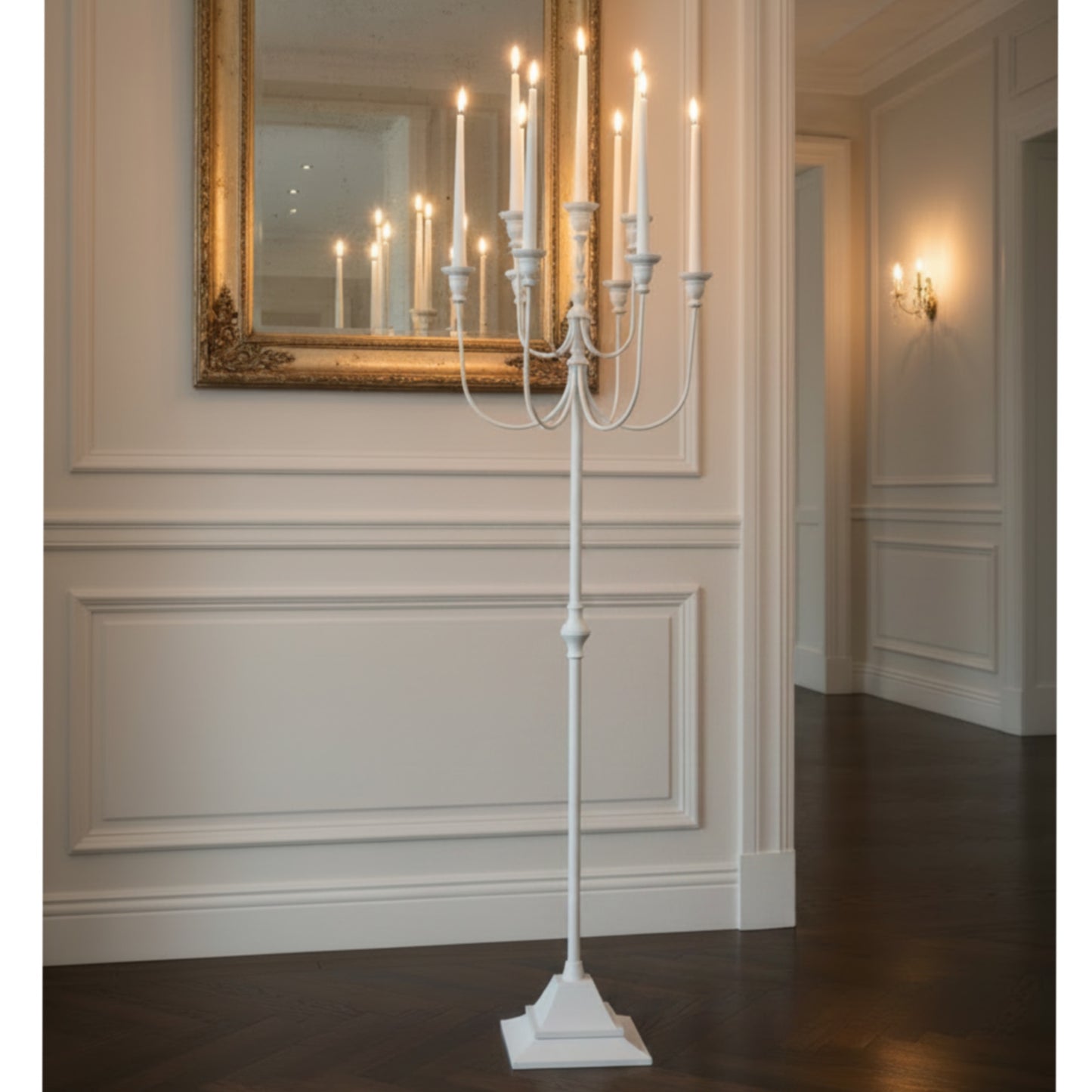 White candelabra with lit candles in a room.