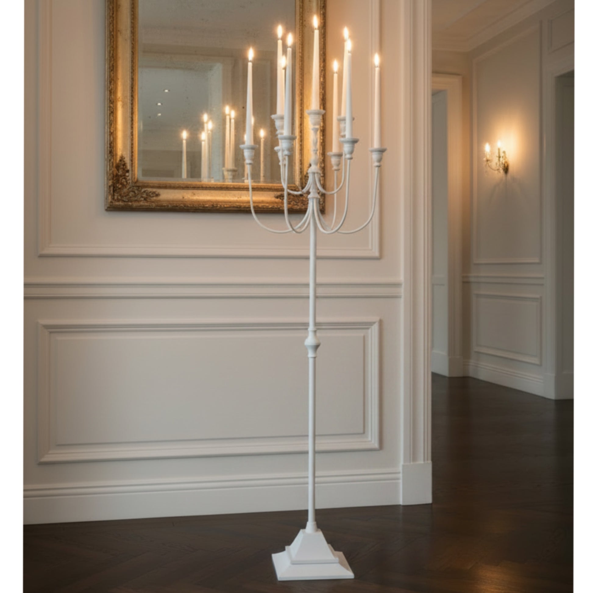 White candelabra with lit candles in a room.
