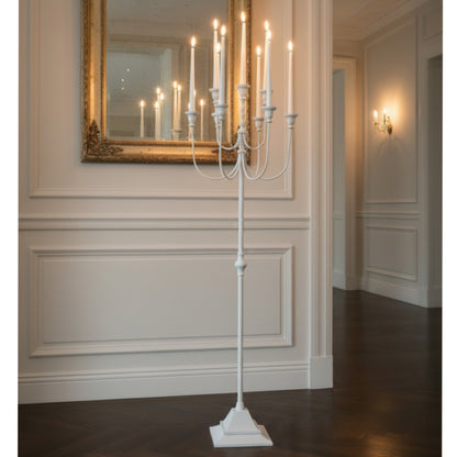 White candelabra with lit candles in a room.
