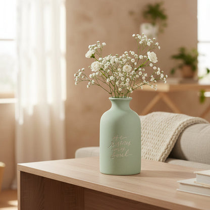 Light green vase with text on a white background