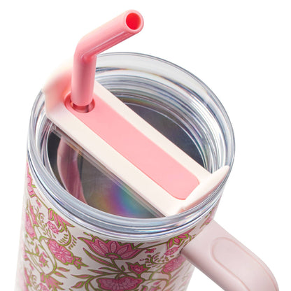 Floral-patterned mug with a pink straw lid on a white background