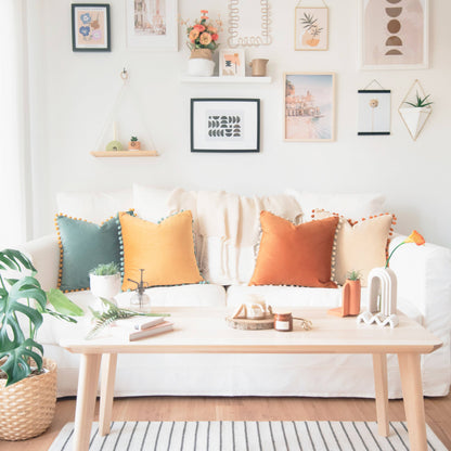 Living room with a white sofa, colorful pillows, and a wooden coffee table.