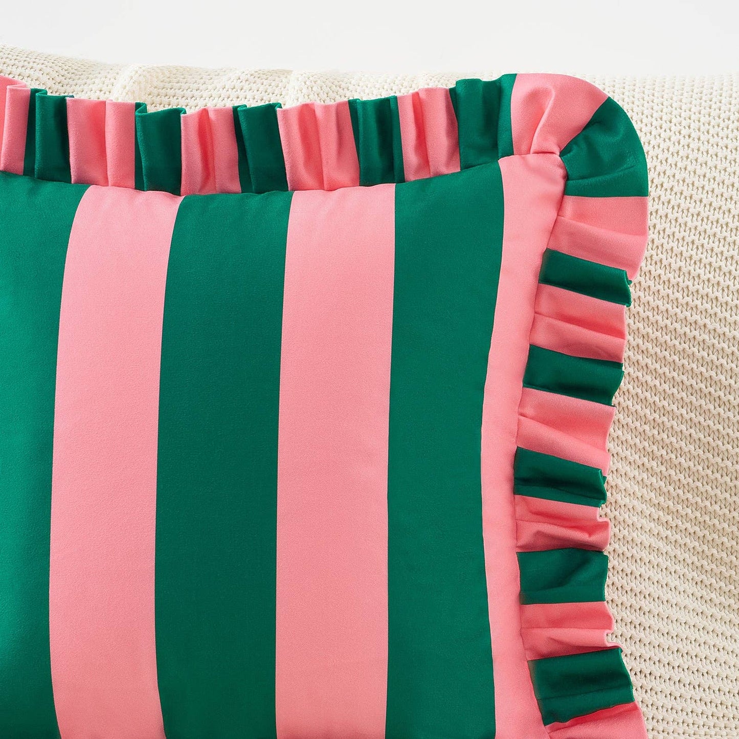 Striped pillow with green and pink horizontal stripes on a textured surface